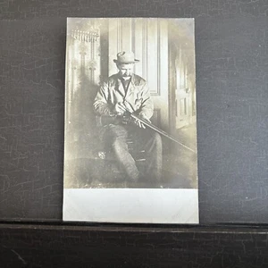 RPPC Man Loading Shotgun in parlor w souvenir spoon collection on wall Postcard - Picture 1 of 4