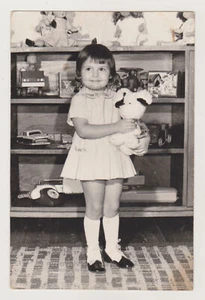 Regal mit ausgefallenem altem Spielzeug Blechautos Puppen ungewöhnlicher Weltraum und Mädchen Foto - Bild 1 von 7