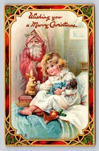 1910 Tuck Christmas Cartolina Babbo Natale Belsnickel abito rosato ragazza coniglietto bambola - Foto 1 di 2