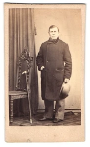 Fotografie Herr mit Kinnbart im Mantel hält Hut - Melone - Bild 1 von 2