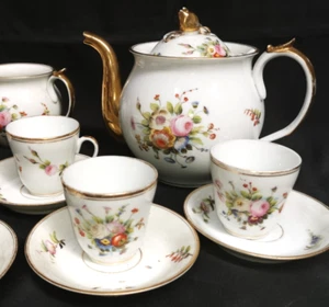 Service mit 8 Kaffeetassen aus weißem, goldfarbenem Porzellan und bemalten Blumen - Bild 1 von 8