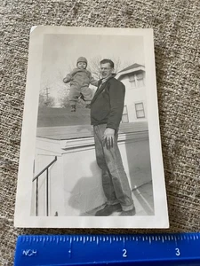 1940's Photo Very Tall Goofy Dad Holds Baby Up By One Hand For Pose Outdoors - Picture 1 of 3