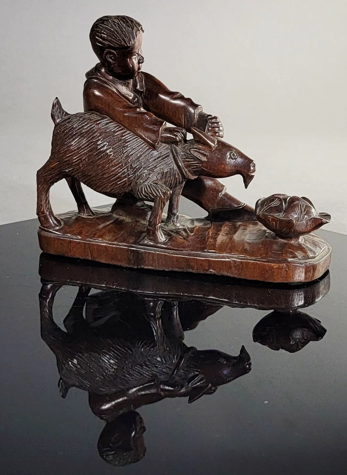 Estatuilla china vintage de madera tallada de un niño sosteniendo una cabra con una flor de loto Foto 1 de 4