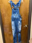 Women "Mavi Jean Co" Blue Jean Overalls With Holes In Knees. Size Not Indicated.