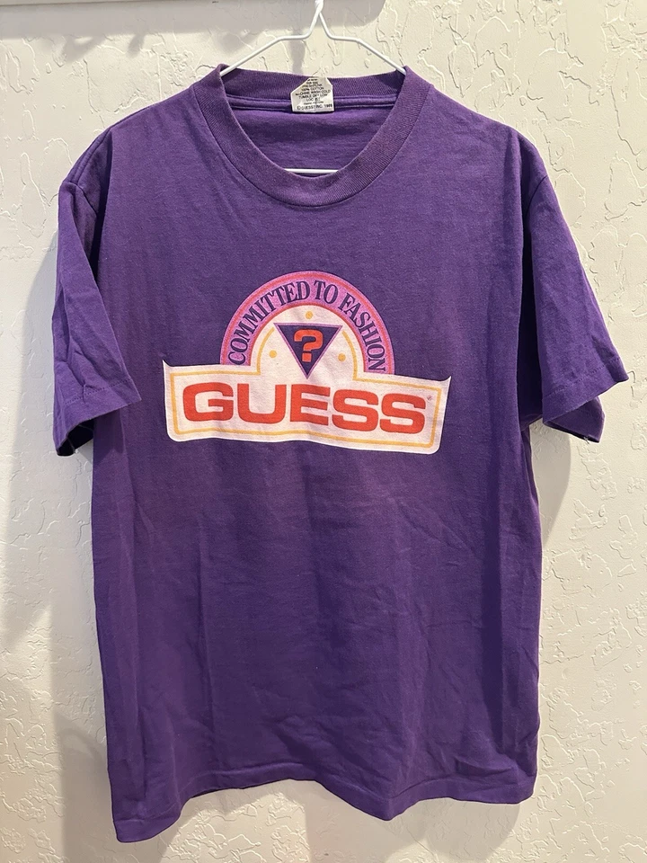 Camiseta Vintage Anos 80 Guess Ponto Único Roxa OSFA 29x20 Fabricada Nos EUA - Imagem 1 de 4