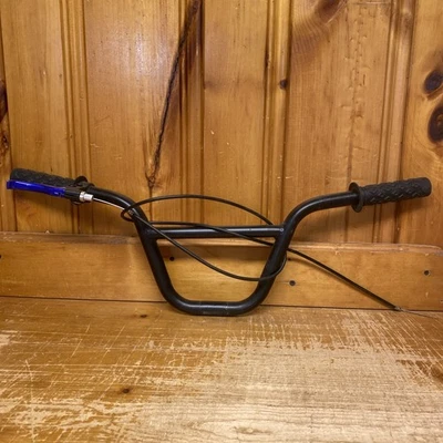 Manillar BMX negro con empuñaduras palanca de freno trasero y línea de freno.           G1 Foto 1 de 4