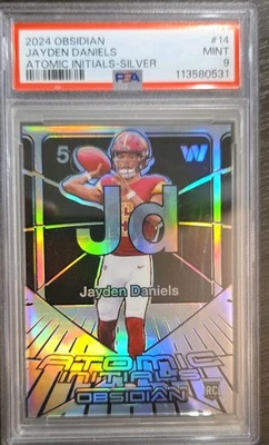 Obsidiana Panini 2024 - Iniciales atómicas Jayden Daniels #14 plata/99 (RC) Foto 1 de 2