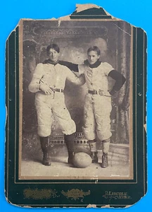 Fotografia antica due giocatori di football americano datata 1900 sul calcio - Foto 1 di 4
