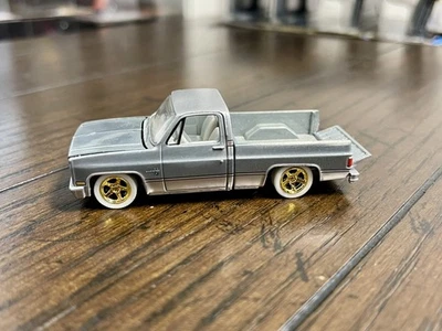 Chevrolet Silverado RAW Chase AUTO WORLD 1:64 Premium Series 2023 R2B 1985 Foto 1 de 3