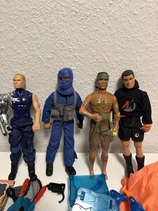Action Man Konvolut – 4 Figuren mit Zubehör & Buch – Waffen, Fallschirm usw. - Bild 1 von 19