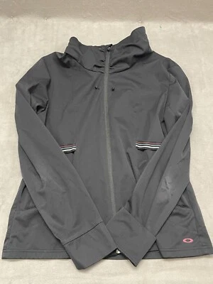 Chaqueta deportiva Oakley para mujer negra con bolsillos en el cuello falso manga larga cremallera completa Foto 1 de 4