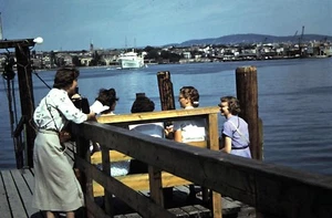 50er Jahre rote Randrutsche, junge Damen sitzend auf einem Bootssteg  - Bild 1 von 1