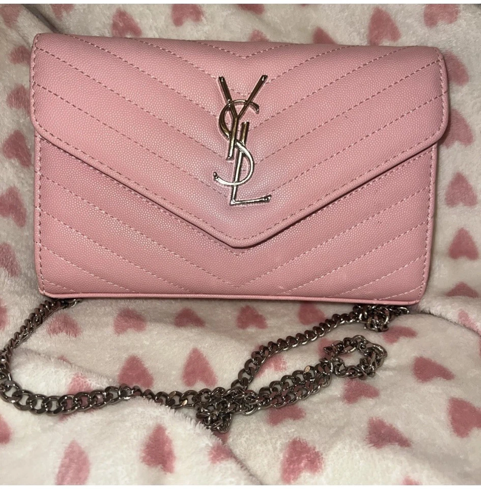 Bandolera de cuero sobre acolchado rosa con herrajes plateados.' Foto 1 de 4