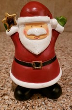Holiday Home Santa Holding gold star hands up in air 6 1/2 tall.