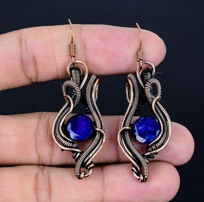 Pendientes de joyería creados en laboratorio envueltos en alambre de cobre hechos a mano con piedras preciosas de zafiro azul Foto 1 de 4