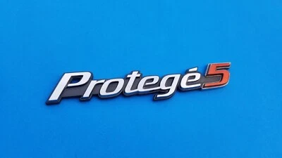 99 00 01 02 03 MAZDA PROTEGE 5 EMBLEMA CROMADO TRASERO LOGOTIPO INSIGNIA SÍMBOLO USADO OEM A15 Foto 1 de 3