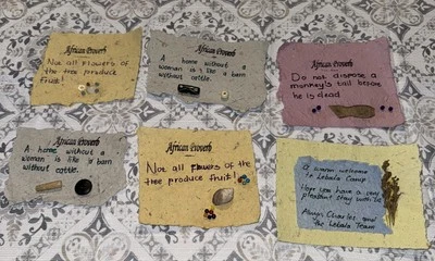 Proverbio africano hecho a mano papel pequeño decora mono mujeres ganado flores Foto 1 de 4