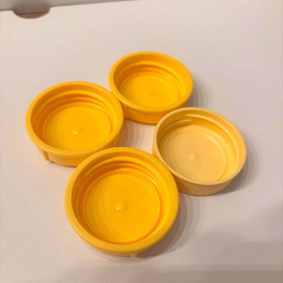 Juego de 4 tapas de biberón amarillas Medela para contenedores de almacenamiento de leche materna Foto 1 de 2