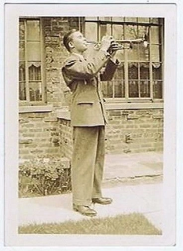 Snapshot Photo of Man Playing a Trumpet on a Sidewalk - Image 1 of 1