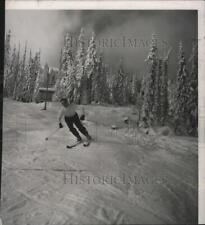 Press Photo A 1950s-era snow skier glides out of the trees - spb16908