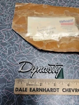 DODGE  DYNASTY EMBLEM ORNAMENT Badge OEM NOS Plastic "DYNASTY" Nameplate Damaged - Image 1 of 4