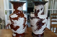 A pair of large ornamental Vietnamese floor vases decorated with dragons