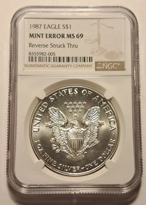 Silver Eagle 1987 $1 error como nuevo NGC MS69 reverso golpeado a través de tal vez retenido Foto 1 de 4
